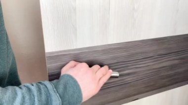 Gri kazaklı ve kot pantolonlu genç adam ofiste, evde, otel odasında, iş seyahati, turizm, işyeri konsepti, açık kapı açıyor.