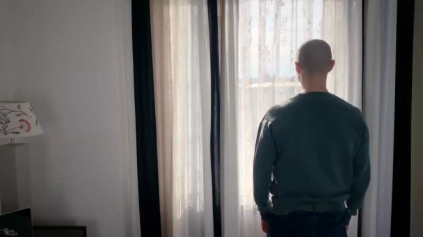 Jeune Homme Tient Devant Fenêtre Ouvre Les Rideaux Regarde Rue — Video