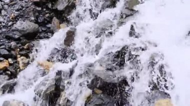 Güçlü temiz su akıntısı hızla dağlardan aşağı akar, taşlardan dökülen şelale damlaları, vahşi doğa konsepti, doğal kaynakların sembolü, alternatif enerji, boğulma tehlikesi