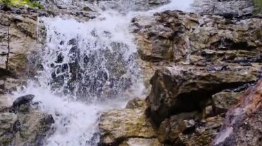 Güçlü temiz su akıntısı hızla dağlardan aşağı akar, taşlardan dökülen şelale damlaları, vahşi doğa konsepti, doğal kaynakların sembolü, alternatif enerji, boğulma tehlikesi