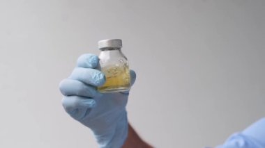 Doktor, bilim adamı, laboratuvar asistanı, bir şişe sıvı, araştırma aşısı, yeni ilaç, modern bilimde yenilik kavramı, COVID-19 için tedavi, test, bilim ve geleceğin tıbbı.