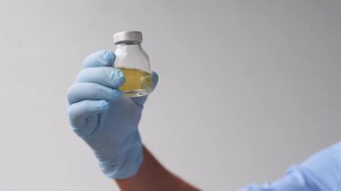 Doktor, bilim adamı, laboratuvar asistanı, bir şişe sıvı, araştırma aşısı, yeni ilaç, modern bilimde yenilik kavramı, COVID-19 için tedavi, test, bilim ve geleceğin tıbbı.