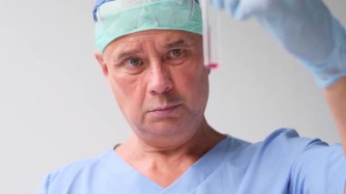 Erkek doktor, bilim adamı, laboratuvar asistanı, elinde bir şişe sıvı, bir aşı, yeni bir ilaç, modern bilimde yenilik kavramı COVID-19 için bir ilaç,