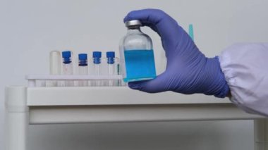 Doktor, bilim adamı, laboratuvar asistanı, bir şişe sıvı, araştırma aşısı, yeni ilaç, modern bilimde yenilik kavramı, COVID-19 için tedavi, test, bilim ve geleceğin tıbbı.