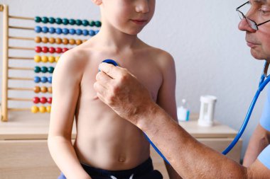 Erkek doktor çocuk doktoru, küçük bir hastanın sağlığını incelemek için stetoskop aleti kullanıyor. Çocuk, çocuk, çocuk, sağlık sigortası, muayene, tedavi...