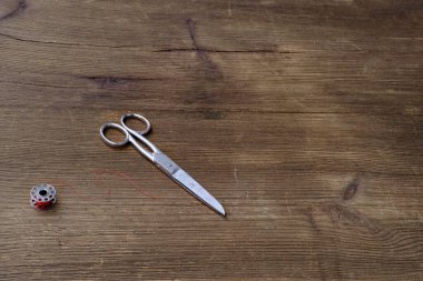 Eski demir makas eski bir ahşap masada yatar, iki parçanın ahengi, yaşam ve ölümün sembolü, kuaförlük, kesim ve dikiş.