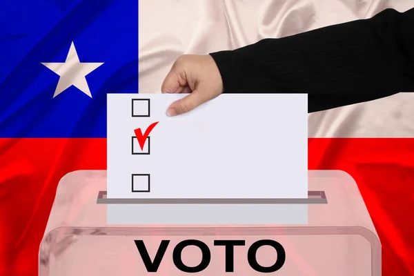 female voter drops a ballot in a transparent ballot box on the background of the national flag of Chile, vote in spanish, concept of state elections, referendum