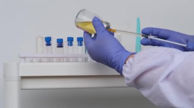 Erkek doktor, bilim adamı, laboratuvar asistanı, elinde bir şişe sıvı, bir aşı, yeni bir ilaç, modern bilimde yenilik kavramı COVID-19 için bir ilaç,