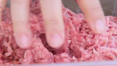 Kadın elleriyle doğranmış et yoğuruyor, yakın plan, domuz eti ve et fabrika plastik tepside yatıyor, çiğ et ürünleri konsepti, yemek malzemeleri alışverişi...