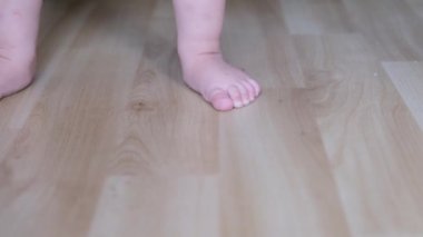 Küçük kız, bebek yerde yalınayak yürüyor, ilk adımlar konsepti, mutlu çocukluk, çocuk oyunları, jenerasyon alfa