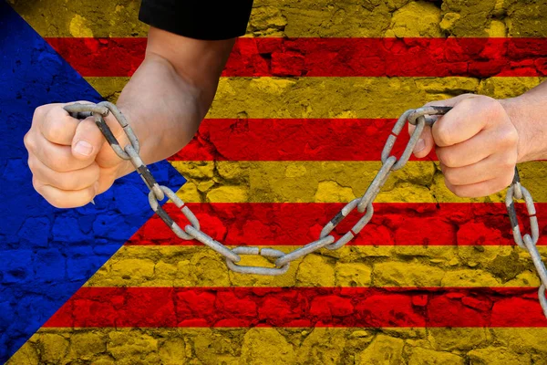 male hands breaking the iron chain, symbol of bondage, protest against the background of the state flag of Catalonia, the concept of political repression, tyranny, arrest, crime, civil rights, freedom