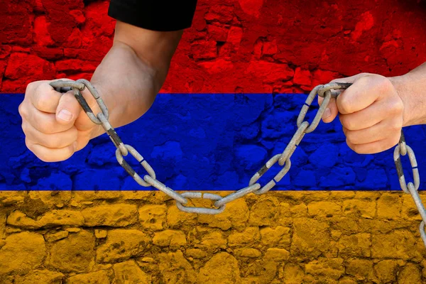 male hands breaking the iron chain, symbol of bondage, protest against the background of the state flag of Armenia, the concept of political repression, tyranny, arrest, crime, civil rights, freedom