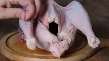 Kadın tavuk işliyor, mutfakta yemek hazırlıyor, kümes hayvanlarını porselen bıçakla parçalara ayırıyor, geleneksel mutfak konsepti, rutin ev ödevleri.