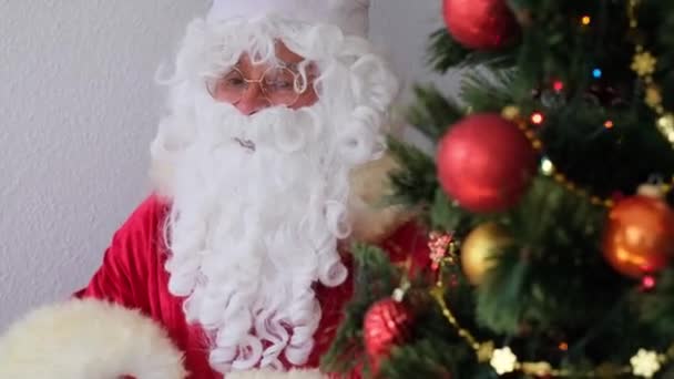 Santa Claus Red Suit Sits Table Tree Beautifully Decorated Balls — Stock Video