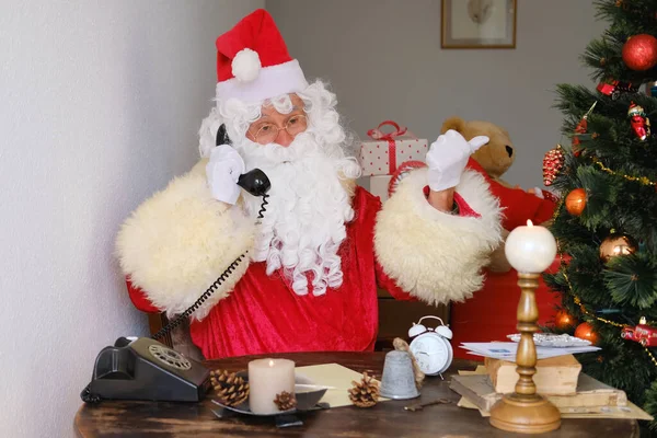 Der Erwachsene Weihnachtsmann Roten Anzug Sitzt Tisch Telefoniert Mit Einem — Stockfoto