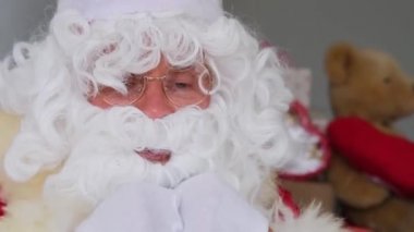 Beyaz sakallı Noel Baba mutlu yıllar diler, satışlar ve indirimlerden bahseder, Noel konsepti, hediyeleri beklemek, neşeli bir ruh hali.