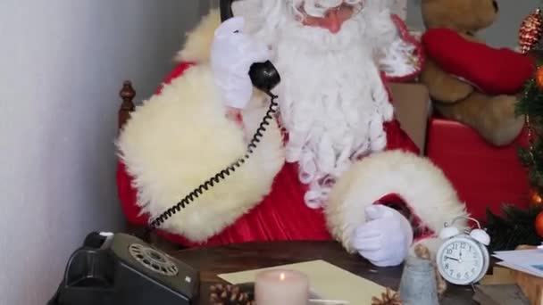 dospělý Santa Claus v červeném obleku sedí u stolu, hovory na starý telefon, strom je krásně zdobené s míčky, koncept Vánoc, novoroční oslavy, dovolená prodej a slevy, Sylvester