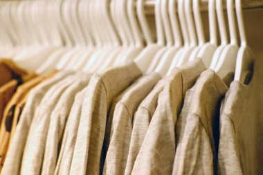 Bir mağazadaki askılarda aynı çocuk kıyafetleri, moda, alışveriş, mevsimlik satışlar, tüketici malları için yüksek fiyatlar