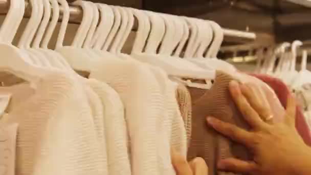 Frau Kauft Ein Geht Durch Eine Reihe Identischer Kleidungsstücke Auf — Stockvideo