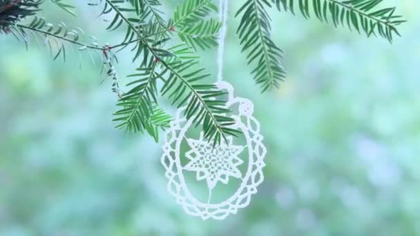 美しい透かし彫り糸で作られたクリスマスツリーの装飾 手織り 針葉樹の枝にかかって 風に揺れる クリスマスの概念 手作りの贈り物 お祝いムード — ストック動画