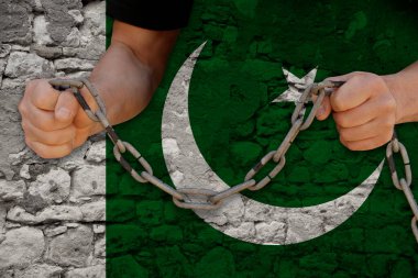 Erkek elleri demir zinciri kırıyor, köleliğin sembolü, Pakistan bayrağının arka planını protesto ediyor, siyasi baskı, zorbalık, tutuklama, suç, sivil haklar, özgürlük kavramını protesto ediyor.