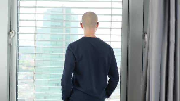 Ung Man Står Ett Kontor Framför Ett Fönster Tittar Modern — Stockvideo