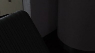 Gri kazaklı ve kot pantolonlu genç adam otel odasına bavuluyla girdi, pencerenin önünde durdu, iş seyahati, turizm kavramı...