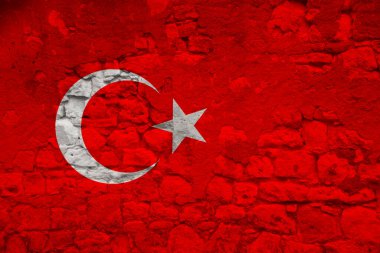 Türkiye devletinin bayrağı, çatlakları, turizm, göç, ekonomi, siyaset, sivil haklar ve özgürlük kavramlarıyla dolu eski taş bir duvarda yer alıyor.