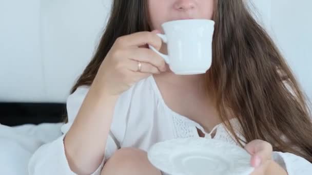 Fiatal Fehér Ruhában Iszik Toning Kávé Tea Egy Csésze Ágyban — Stock videók