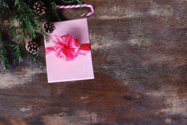 Kozalaklı ağaçların yeşil dalları, kozalaklar, hediyeler eski ahşap masanın üzerinde yatıyor. Noel konsepti, şenlik havası, yeni yıl tatili.