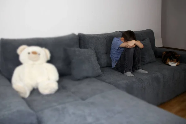 Smutny Dzieciak Chłopiec Siedzi Szarej Kanapie Pokoju Ukrył Twarz Miś — Zdjęcie stockowe