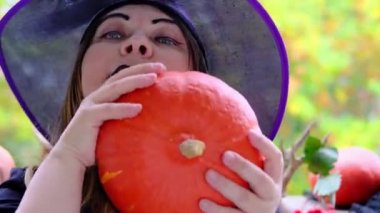 Siyah koçanlı cadı elinde turuncu bir balkabağı, bayram bayramı konsepti, aşk büyüsü, kehanet, parti hazırlığı