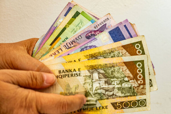 Hand holding fan Albanian lek banknotes, Albanian paper money cash currency notes, financial background, economy and banking concept, national banking system, business, financial and investment