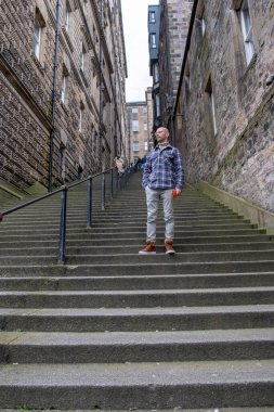 Genç gezgin, ortaçağ sokaklarını keşfediyor Edinburgh, tarihi Eski Şehir seyahati, tek başına seyahat macerası, İskoç tatili, ortaçağ İskoçyası 'nın yakalama anları.