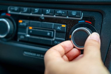 Sıcaklığı ayarlayan el, iklim kontrol sistemi, AC, AUTO, ikili bölge ayarları, iklim konforu, kullanıcı arayüzü tasarımı, otomotiv ergonomisi için aydınlatılmış düğmeleri olan 19C kümesi. 