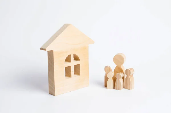 若いご家族連れは木造の家の近くに立っています 強い家族 家族の継続の概念 手頃な価格の住宅の購入のためのローン 家族のための新しい家 — ストック写真