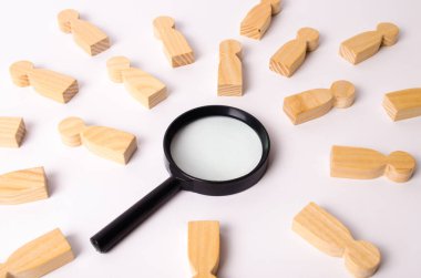 Ahşap figürler insan Büyüteç beyaz bir arka plan üzerinde etrafında yalan. İnsanlar ve işçiler, insan kaynakları için arama kavramı. İnsanlar izleme iş için işe.