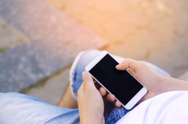 adam bir hareket eden smartphone tutarak ve ekrana bakarak. telefon bağımlılığı, sosyal ağlar. Internet üzerinde çalışma. mesajı yazın. güneşli bir gün. yakın çekim, metin için yer