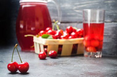 meyve suyu veya komposto kiraz ile. bir gri beton zemin, yaz berry, yaz içeceği sepet içinde taze Olgun kırmızı kiraz