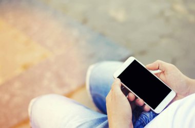 adam bir hareket eden smartphone tutarak ve ekrana bakarak. telefon bağımlılığı, sosyal ağlar. Internet üzerinde çalışma. mesajı yazın. güneşli bir gün. yakın çekim, metin için yer