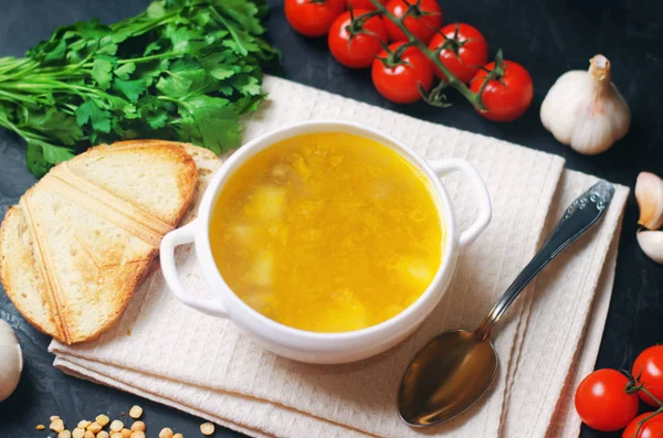 Vejetaryen bezelye çorbası patates ve Yeşiller ile. baklagiller gıda. sağlıklı kahvaltı. siyah beton zemin. seçici odak.