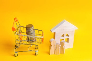 aile house yanında duruyor. ahşap küçük adamlar. Bir alışveriş sepeti para çıktı. Emlak kavramı. Satın alma, satış ve bir ev kiralama. Kredi bir daireye, ipotek oranı için. Genç aileler için uygun fiyatlı konut.