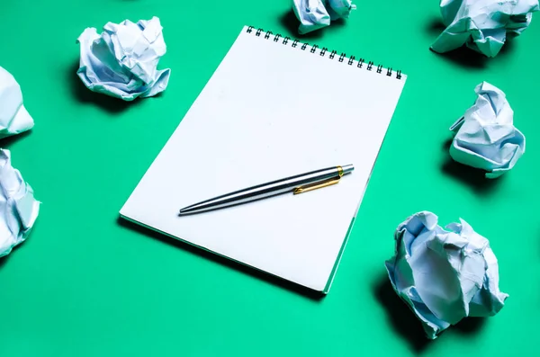 Witte Notebook Met Pen Een Groene Achtergrond Onder Papier Ballen — Stockfoto