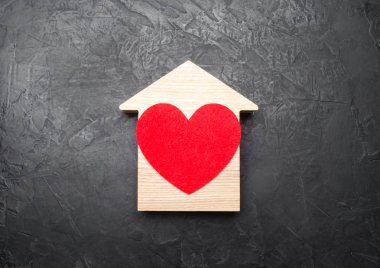 Kırmızı kalp gri beton zemin üzerine bir ahşap evin içinde. Bir aşk yuvası kavramı, Genç çiftler ve aileler için yeni affordable housing için arama. En sevdiğim ev, vatan hasreti.