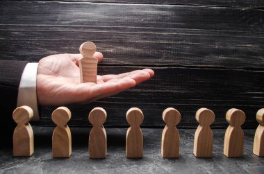 Bir işadamı bir ahşap lider figürü diğer işçiler, bir dizi üzerinden elini avuç içinde tutar. Kavramı lider, takım çalışması. İş ve departman yönetimi. Büyük patron. Promosyon. Kariyer.