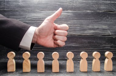 İşadamı'nın el bir başparmak-up, işçiler ve rakamlar üzerinde gösterir. İş fikirleri, iş başarısı için tebrikler onaylanması kavramı. İş geliştirme, promosyon.