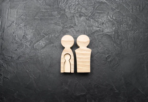 Kadının bedeni beton gri arka plan üzerinde içinde bir çocuk şeklinde ahşap biblo anne. Hamilelik ve çocuk beklentisi kavramı. Mutlu anne. Sağlıklı aile.