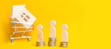 İnsanlar süpermarket arabası ahşap bir evde arka plan üzerinde sikkelerinde stand. Emlak kavramı. Satın alma, satış ve bir ev kiralama. Kredi bir daireye, ipotek oranı için. Genç aileler için uygun fiyatlı konut. boşaltmak. afiş