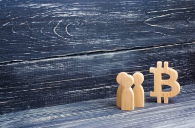 Ahşap figürler insan yakınındaki bir bitcoin siyah bir arka plan üzerinde duruyor. Kripto para birimi, blockchain teknoloji. Bitcoin çöküşü ve yükselişi maliyeti. Araştırma çiftlikleri, madenciler, Menkul Kıymetler Borsası kriptalarının