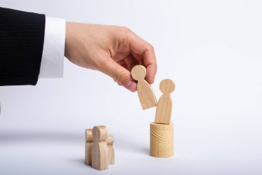 Elini bir işadamı iş takım elbiseli bir adam ahşap bir rakam elinde tutuyor ve başka bir şekil görevinden taşır. Bir çalışan personel yerine ateş kavramı